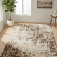 Patterned rug on a wooden floor with a plant and side table in the background