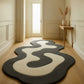 Modern abstract rug on a wooden floor with a neutral-colored wall and door in the background.