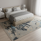 Modern bedroom with a bed, nightstands, and a patterned rug.