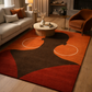 Living room with a modern rug featuring geometric shapes, a sofa, and armchair.