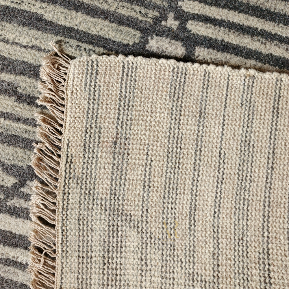Close-up of a textured rug with striped pattern and frayed edge.