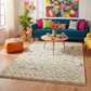 Colorful living room with a blue sofa, patterned rug, and decorative items.