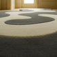 Close-up of a round rug with concentric circle pattern in a room.
