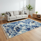 Living room with a blue floral rug, gray sofa, and wooden side table.