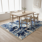 Dining room with a blue and white floral rug, wooden table, and chairs.