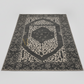 Decorative rug with central geometric design on a plain background