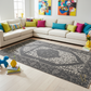 Living room with a sectional sofa, colorful pillows, and a decorative rug.
