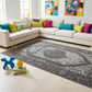 Living room with a sectional sofa, colorful pillows, and a decorative rug.