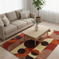 Living room with a beige sofa, coffee table, and a colorful circular rug.