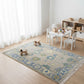 Children's playroom with a patterned rug, toys, and a small table.