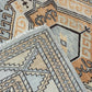 Close-up of patterned rugs with geometric designs in beige, brown, and gray.