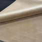 Close-up of beige fabric with a logo on a dark background