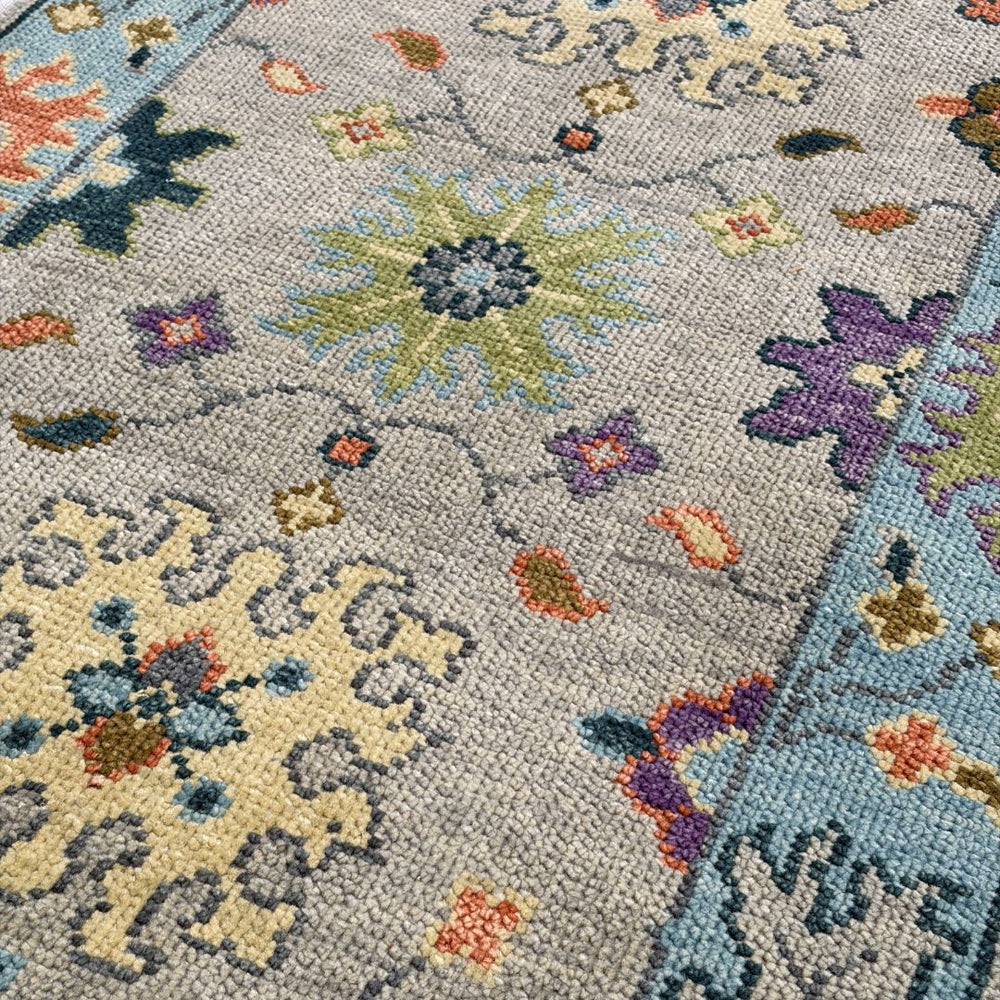 Close-up of a floral patterned rug with multicolor design on a gray background