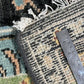 Close-up of a textured rug corner with a ruler for scale.