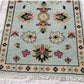 Decorative rug with intricate patterns on a light blue background