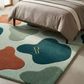 Colorful abstract rug with a brand logo in a bedroom setting