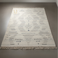 Patterned rug on a plain floor with a visible brand logo.