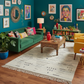 Colorful living room with a green sofa, yellow chair, and decorative elements.