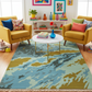Colorful living room with a patterned rug, yellow chairs, and colorful decor.