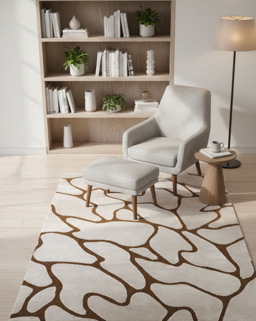 Modern living room with a gray armchair, ottoman, and patterned rug.