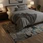 Cozy bedroom with a bed, nightstands, and a patterned rug.