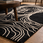 Black rug with white line art of a face in a living room setting