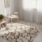Children's playroom with a patterned rug on a wooden floor, white walls, and toys scattered around.