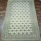 Green and beige patterned rug on a wooden floor