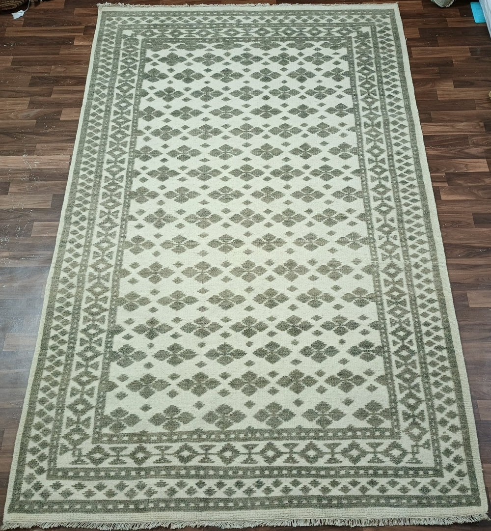 Green and beige patterned rug on a wooden floor