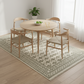 Dining room with a round wooden table and four chairs on a patterned rug.