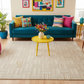 Living room with a blue sofa, colorful pillows, and a yellow coffee table.