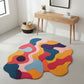 Colorful abstract rug on a light gray floor with a wooden console table and plant in the background.