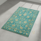Teal floral patterned rug on a gray floor