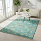 Living room with a blue patterned rug, white sofa, and small round table.
