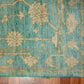 Teal and beige floral patterned rug on a wooden floor