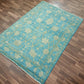 Turquoise rug with floral patterns on a wooden floor