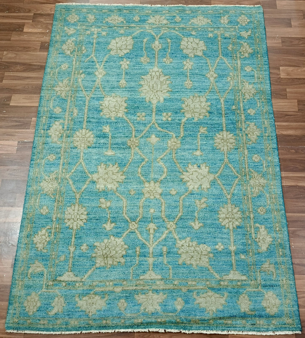 Blue floral patterned rug on a wooden floor