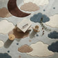 Children's play area with toys on a rug featuring clouds and a moon.