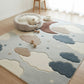 Children's room with a cloud-patterned rug, a small dog bed, and a small table with a plant.