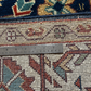 Close-up of a patterned rug with a metal ruler for scale