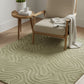 Beige armchair with a patterned rug and side table in a room setting