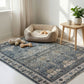 Pet bed on a patterned rug with toys in a bright room