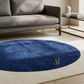 Blue oval rug with a logo on a beige floor in a living room setting.