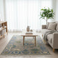 Living room with a patterned rug, sofa, coffee table, and plant.