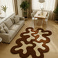 Modern living room with a unique brown and white rug, sofa, and dining table.