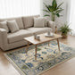 Living room with a beige sectional sofa, wooden coffee table, and patterned rug.