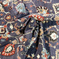 Close-up of patterned fabric with intricate designs on a dark blue background