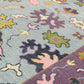 Close-up of a colorful patterned fabric with abstract shapes and pastel colors.