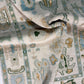 Close-up of a patterned fabric with geometric designs in beige, blue, and green.
