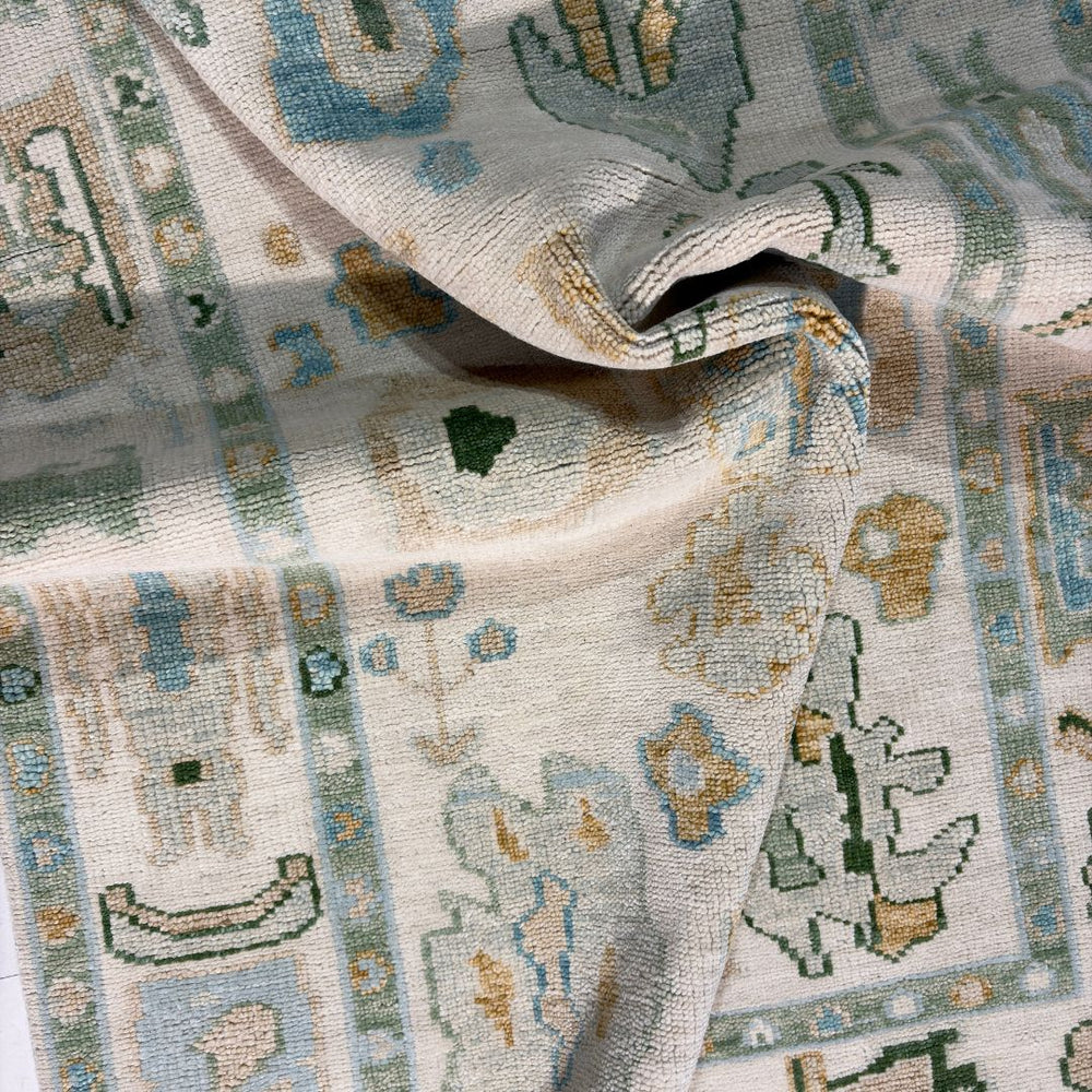 Close-up of a patterned fabric with geometric designs in beige, blue, and green.